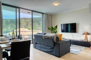 sala de estar con sofá, mesa y TV en Baia Machico, a Home in Madeira, en Machico