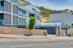 un edificio de apartamentos con una palmera frente a una calle en Baia Machico, a Home in Madeira, en Machico