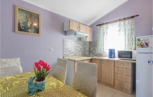 a kitchen with a table and a kitchen with a refrigerator at 2 Bedroom Gorgeous Apartment In Peroj in Peroj