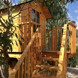 una escalera de madera que conduce a una casa en el árbol en El Marqués, magnífica casa rural con piscina, en Almería