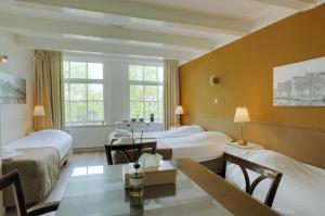 Cette chambre comprend 2 lits et une table. dans l'établissement Hotel Prinsenhof Amsterdam, à Amsterdam