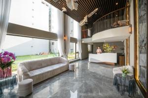 un vestíbulo con sofás y una mesa en un edificio en Tashi Ocean Hotel & Apartment Da Nang en Da Nang