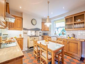 a kitchen with a table and a clock on the wall at Cartref in Capel Curig