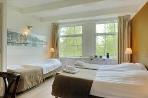 a bedroom with two beds and a window at Hotel Prinsenhof Amsterdam in Amsterdam
