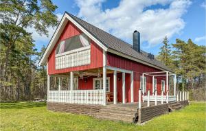 czerwony dom z tarasem na polu w obiekcie Cozy Home In Klintehamn With Wifi w mieście Klintehamn
