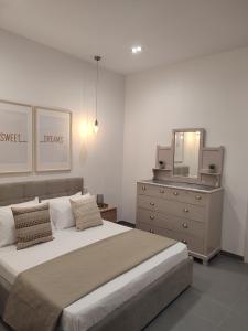 een slaapkamer met een bed, een dressoir en een spiegel bij Casetta Pulis (Close to Airport & Valletta) in Tarxien