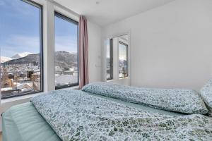 a bedroom with a bed with a view of a city at Luxury apartment in the center of Tromsø in Tromsø