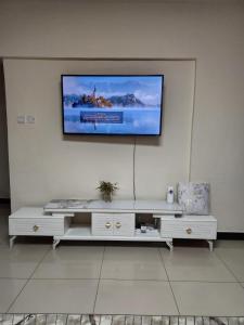 uma sala de estar com uma televisão na parede em KJ Airbnb em Nairobi