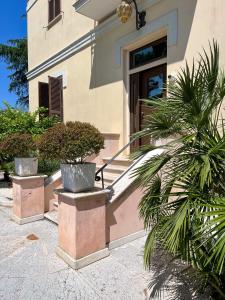 Una casa con tres plantas en macetas delante de una puerta. en La Villa, Tiburtina Valley, en Roma