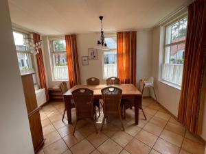 a dining room with a wooden table and chairs at Freistehendes Ferienhaus am See Nähe Roermond in Heel