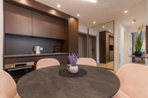a kitchen and dining room with a table and chairs at Lux Ella Apartment in Makarska
