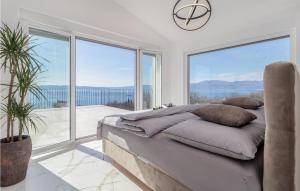 a bedroom with a bed and large glass windows at Villa Green Wave in Kostrena