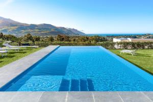una piscina blu con vista sull'oceano di La Dolce Vita a Castellammare del Golfo