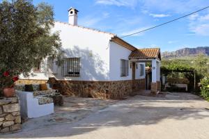 une maison blanche avec un portail et un arbre dans l'établissement El Llano de la Encina, à Antequera
