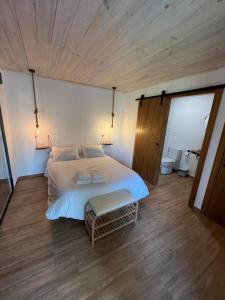 a bedroom with a white bed and a wooden floor at Casa rural Rio de Cotillas in Cotillas +16 photos