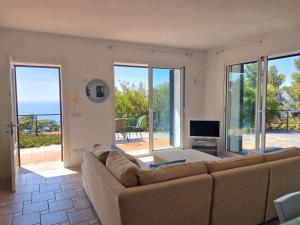a living room with a couch and a television at Appartamento in Villa Mimosa in Cervo