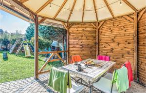 a patio with a table and chairs and a playground at 5 Bedroom Stunning Home In Grzybowo in Grzybowo