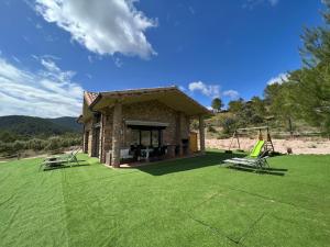 a house with a yard with two chairs and a swing at Casa rural Rio de Cotillas in Cotillas