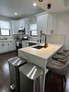 a kitchen with a sink and a counter with stools at Secret Escape - 20 min from NYC N 2 in Jersey City