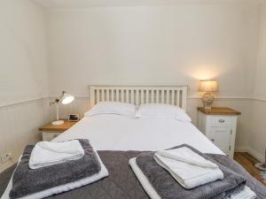Un dormitorio con una cama blanca con toallas. en 2 Hartburn Road, en North Shields