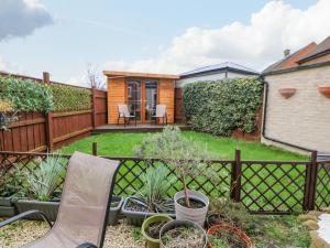 un patio trasero con una valla, sillas y plantas en 2 Hartburn Road, en North Shields
