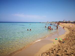 a group of people in the water at a beach at Domus Alba Apartment in Trapani