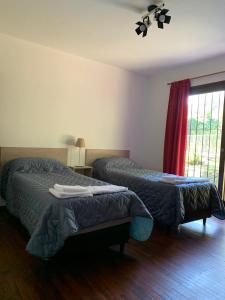 a bedroom with two beds and a window at Casa en Barrio el Golf in Alta Gracia
