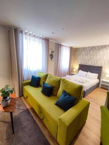sala de estar con sofá verde y cama en Braga Center Apartments - Dom Pedro V en Braga