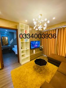 Una sala de estar con un sofá y una lámpara de araña. en Homestay Bãi Cháy HaLong 1 2 3 5 phòng ngủ Liên hệ em tư vấn, en Ha Long