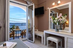 um quarto com uma varanda com vista para o oceano em Ipsos di Mare em Corfu Town