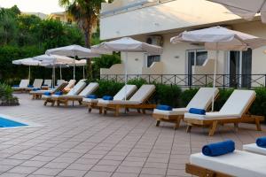 szereg leżaków i parasoli przy basenie w obiekcie Ipsos di Mare w Korfu