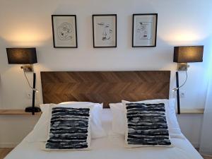 a bedroom with a bed with three pictures on the wall at LA TOUR AUX CRABES près de la plage in Dieppe