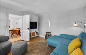 ein Wohnzimmer mit einem blauen Sofa und einem Tisch in der Unterkunft Nice Home In Sby r With Wifi in Søby