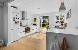 eine Küche mit weißen Schränken und einer Kücheninsel in der Unterkunft Nice Home In Sby r With Wifi in Søby