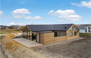 a house with a black roof on top of a field at Nice Home In Harbore With Sauna in Harboør