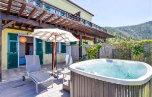 a hot tub on a deck with a chair and an umbrella at 3 Bedroom Beautiful Home In Moneglia in Moneglia