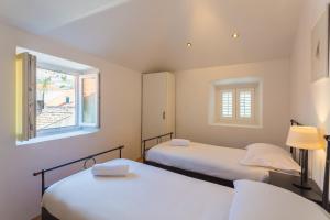 a bedroom with two beds and a window at Old City Apartments in Dubrovnik