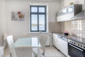 a kitchen with a glass table and white appliances at SeaView mit Badesteg in Malchow