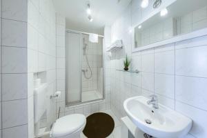 a white bathroom with a toilet and a sink at SeaView mit Badesteg in Malchow
