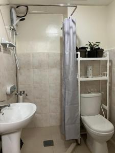 a bathroom with a white toilet and a sink at Davao Vacation Hub near Sasa ferry terminal with netflix,Wifi, pool access in Davao City