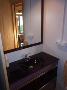 baño con lavabo negro y espejo en Cabaña rustica en plena naturaleza en playa de Nerga, Ría de Vigo,, en Hío
