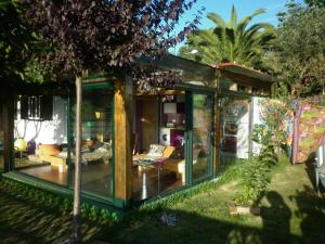 une maison en verre avec un salon dans une cour dans l'établissement Cabaña rustica en plena naturaleza en playa de Nerga, Ría de Vigo,, à Hio