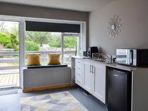 a kitchen with a counter with a microwave and a window at The Dairy in Crossmichael