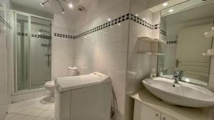 ein weißes Bad mit einem Waschbecken und einem WC in der Unterkunft Petit Bijoux in Beausoleil