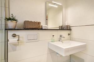 bagno bianco con lavandino e specchio di Seensucht a Langenargen