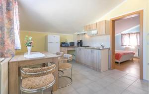 a kitchen with a table and chairs in a room at Nice Apartment In Peroj With 2 Bedrooms And Wifi in Peroj