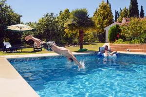 un hombre saltando a una piscina en Villa Lagos Algarve for families & friends, 6 bedrooms, 7 bathrooms, pool, BBQ, central heating en Pedra Alçada
