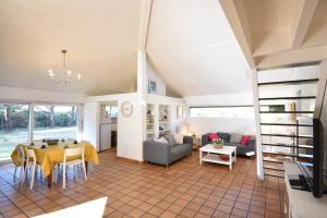 a living room with a table and a couch at Tiokers - Hossegor - Confortable villa sur terrain clos idéalement située entre lac et Océan et à 1200m du centre ville in Soorts-Hossegor