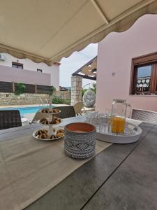 un tavolo con vassoio di cibo e bicchieri di succo d'arancia di Villa Steki a Roumelí