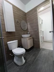 a bathroom with a toilet and a sink and a mirror at Quinta La Bonita Restrepo Meta 